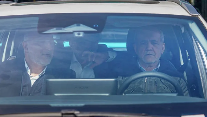 The Iranian president travels in a taxi after his motorcade breaks down due to fuel contamination.